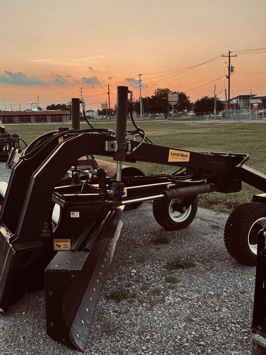 Level Best grading attachment on gravel at sunset