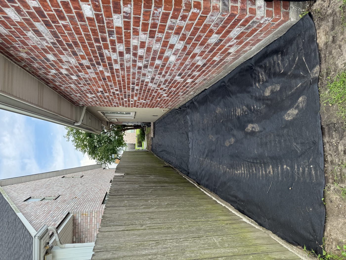 Landscape fabric laid in a narrow side yard before gravel